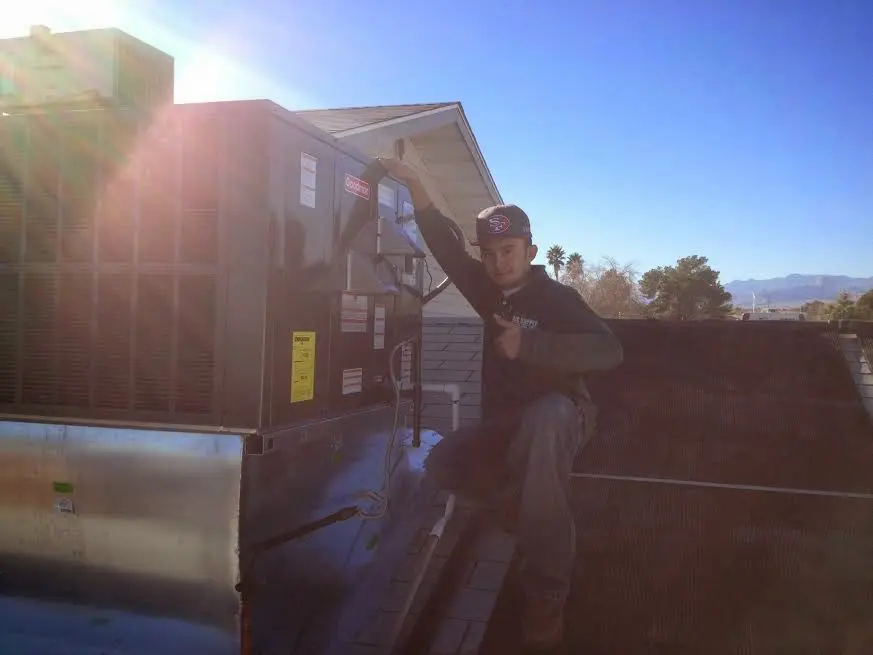 HVAC technician performing Boiler Repair on a rooftop unit in Monticello